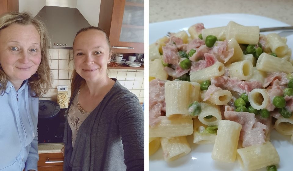 Hotové smetanové rigatoni s hráškem a šunkou, podávané s úsměvem.